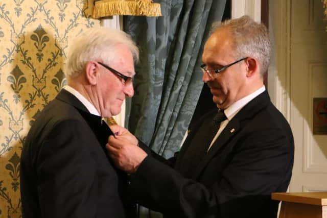 Jerome Mullen receiving his Gold Cross of Merit from Polish Consul General Dariusz Adler at Belfast Castle