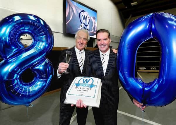Wilsons Auctions Managing Director Ian Wilson and Group Operations Director, Peter Johnston raise a toast as the company reaches its 80th Anniversary.
