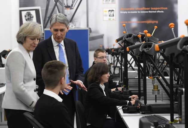 Prime Minister Theresa May and Chancellor Philip Hammond pictured on a visit to a business in Gloucestershire the day after his statement