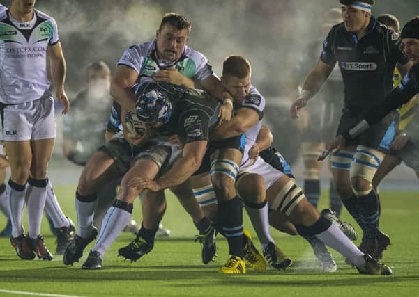 Ospreys' Olly Cracknell and Sam Parry tackle Josh Strauss of Glasgow