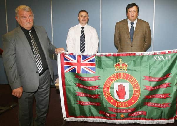Jim Wilson with his Loyalist Communities Council flag, unveiled earlier in 2016. Pictured in the background is Winston Irvine and David Campbell.