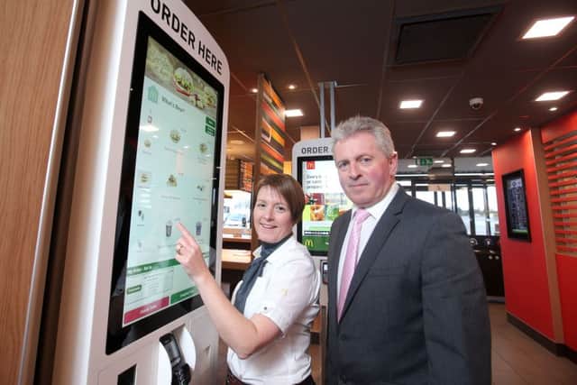 McDonalds franchisee John McCollum and business manager Rita Frost test out the new customer order touch screens.