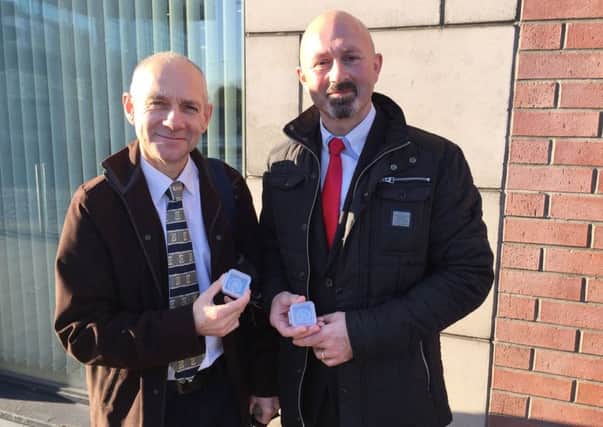 Dr Greer Ramsey from National Museums Northern Ireland (left) stands with treasure hunter Brian Morton holding two extremely rare Viking coins which he unearthed after 10 years of metal detecting and were declared treasure at an inquest in Belfast's Laganside House. Photo: Lesley-Anne McKeown/PA Wire