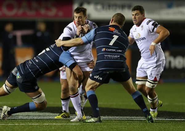 Tommy Bowe of Ulster is tackled by James Down and Gethin Jenkins of Cardiff Blues.