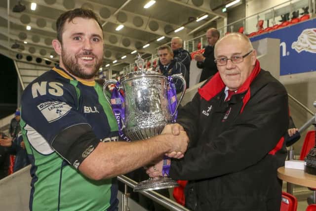 Ballynahinch's captain Michael Graham is presented with the trophy by Ulster Branch President John McKibbin after they won the match.  Picture by Jonathan Porter/Press Eye