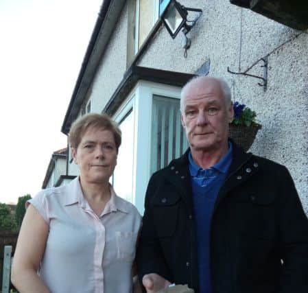 Philip and Therese Corken with the large stone that was hurled through the bedroom window of their Limehurst Way home on Friday morning.