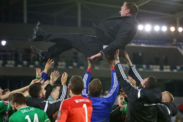 Northern Ireland players throwing manager Michael O'Neill in the air as they celebrate defeating Greece to qualify for Euro 2016. Photo by William Cherry

 / PressEye