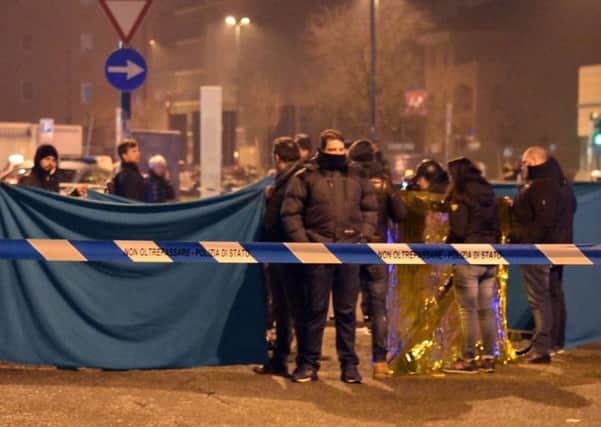 Italian police cordon off an area around a body after a shootout between police and a man in Milan, Italy. Italy's interior minister Marco Minniti says the man killed in an early-hours shootout in Milan is "without a shadow of doubt" the Berlin Christmas market attacker Anis Amri. (AP Photo/Daniele Bennati)