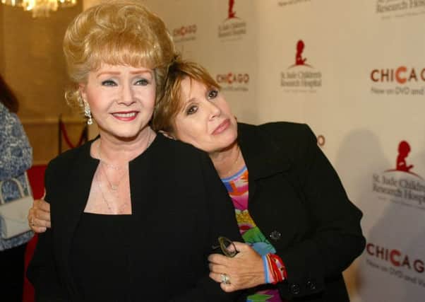 Debbie Reynolds (left) and Carrie Fisher arrive at the "Runway for Life" Celebrity Fashion Show, California in 2003. (AP Photo/Jill Connelly, File)