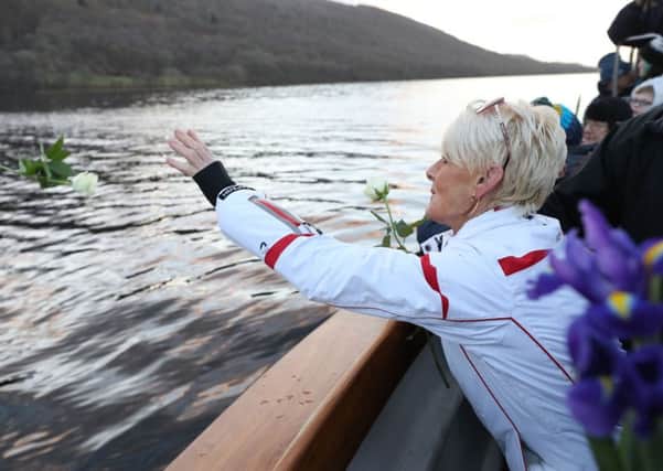 Gina Campbell, the daughter of  world land and water speed record holder Donald Campbell, casts flowers on to the waters of Lake Coniston to mark the 50th anniversary of the fatal crash there of his jet-powered Bluebird boat