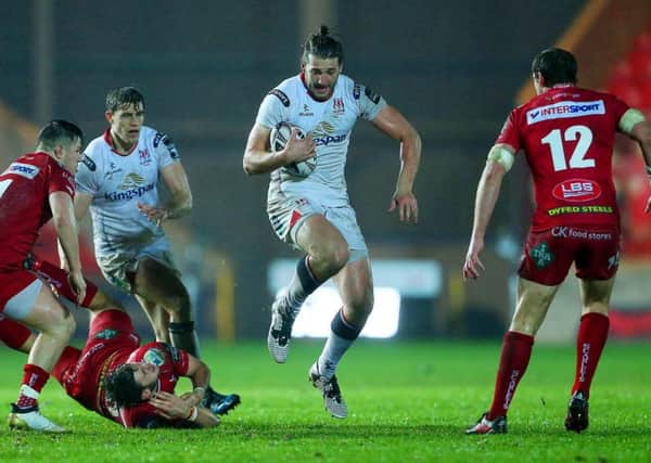 Stuart McCloskey of Ulster is tackled by Steff Evans of Scarlets.