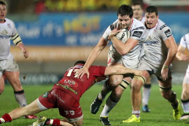 Iain Henderson of Ulster is tackled by Steff Evans of Scarlets.