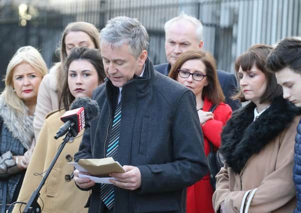 Peter Dolan, surrounded by family members, makes his statement outside the High Court in Belfast