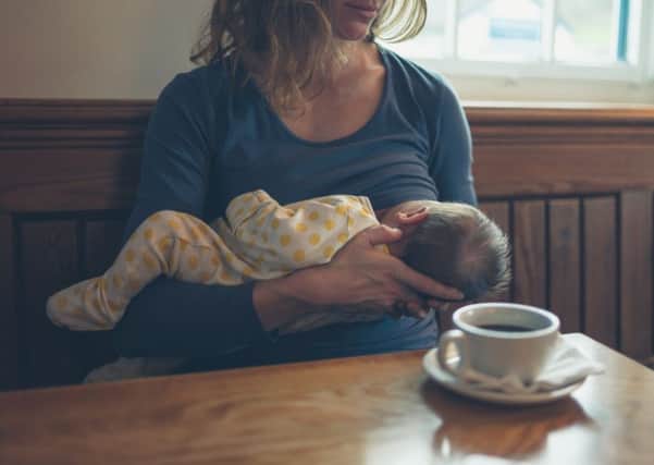 A young mother breastfeeding in a cafe