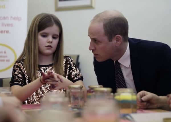 The Duke of Cambridge speaks with Aoife, 9, during a visit to Child Bereavement UK's centre in Stratford, east London