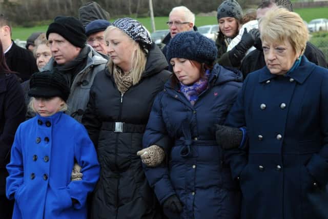 Jean Caldwell (far right) whose husband Cecil was killled at Teebane, stands arm in arm with family members at the service to mark the 20th anniversary of the atrocity.