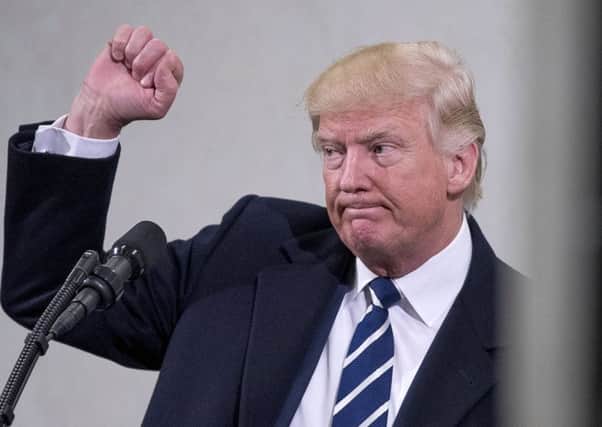 President Donald Trump holds up a fist after speaking at the Central Intelligence Agency in Langley, Va., Saturday, Jan. 21, 2017. (AP Photo/Andrew Harnik)