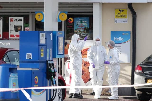 Forensic experts examine the scene of Sundays gun attack on a police officer at a garage forecourt on the Crumlin Road in north Belfast