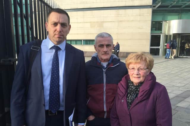 (Left to right) Family solicitor Padraig O Muirigh with Henry Thornton's son Damien and widow Mary outside Belfast Coroner's court, where a coroner has named a British soldier who shot dead father of six Henry Thornton outside a Belfast police station after mistaking a van backfiring for a gun attack.