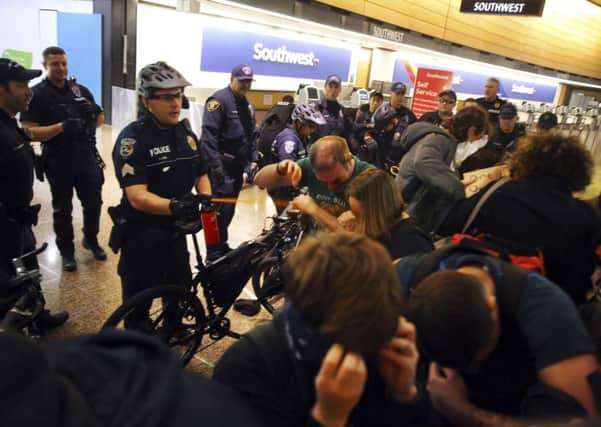 Seattle Police use pepper spray and push the last group of protesters out of a Seattle-Tacoma International Airport terminal after giving a final dispersal order around 2:00 a.m Sunday, Jan. 29, 2017, in Seattle. (Genna Martin/seattlepi.com via AP)