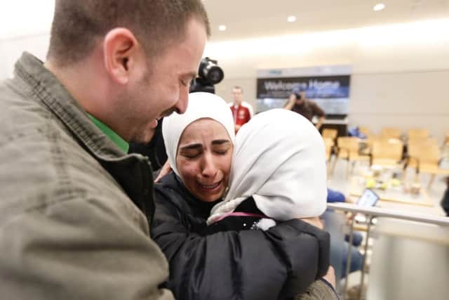 Hisham, left, and Mariam Yasin, center, welcome their mother Najah Alshamieh, from Syria, after immigration authorities released her at Dallas Fort Worth Airport, Saturday, Jan. 28, 2017. (Brandon Wade/Star-Telegram via AP)