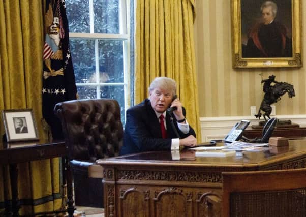 President Donald Trump speaks on the phone with King of Saudi Arabia Salman bin Abd al-Aziz Al Saud in the Oval Office at the White House in Washington, Sunday, Jan. 29, 2017. (AP Photo/Manuel Balce Ceneta)