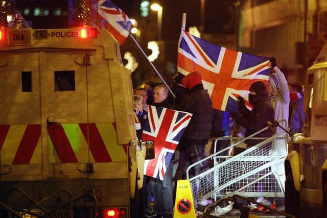 File photo dated 03/12/12 of Loyalist protesters carrying Union flags clashing with police outside the City Hall in Belfast.