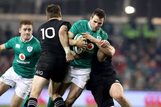 Ireland's Jared Payne tackled by Beauden Barrett and Dane Coles of New Zealand