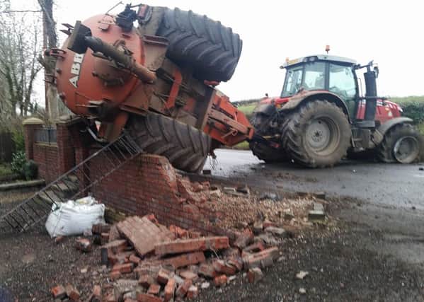 A vehicle collided with a tractor on the Belfast Road, Glenavy and then the tractor with a slurry trailer crashed into the wall of a house.
 Pic: Pacemaker Press