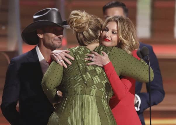 Tim McGraw, left, and Faith Hill, right, congratulate Adele after presenting her with the award for record of the year for "Hello" at the 59th annual Grammy Awards on Sunday, Feb. 12, 2017, in Los Angeles. (Photo by Matt Sayles/Invision/AP)