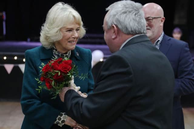 The Duchess of Cornwall, President of the Royal Voluntary Service, is given roses by RVS volunteer Dave Hancock at a tea party and swing dance at The Trinity Centre in Bristol