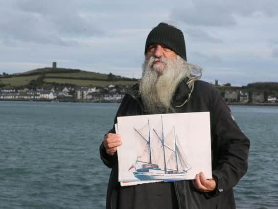 William Mulhall, owner of the historic Tall Ship Regina Caelis, which sank at the quayside in Portaferry, County Down last month, holds a photograph of the ship at Strangford Lough where the vessel remains, as he has appealed to the Queen of Denmark for help to raise it.