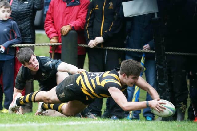 RBAI's Joseph Finnegan runs in a try, tacked by Campbell's Ben Power