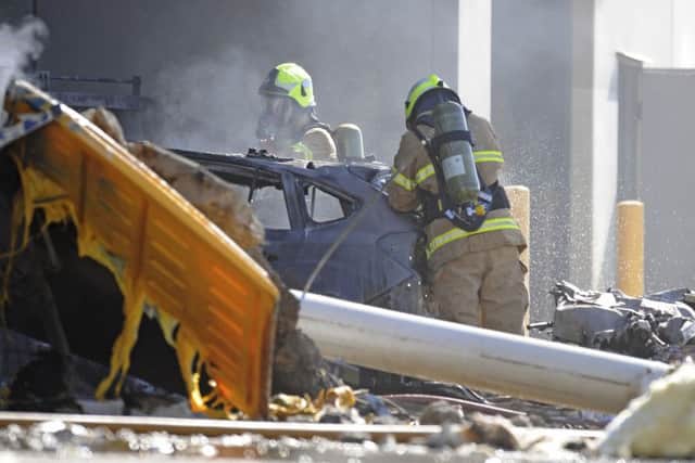 Emergency personnel work at a light plane crashed in Melbourne, Australia, Tuesday, Feb. 21, 2017. The plane crashed into a shopping mall, officials said. (Joe Castro/AAP Image via AP)