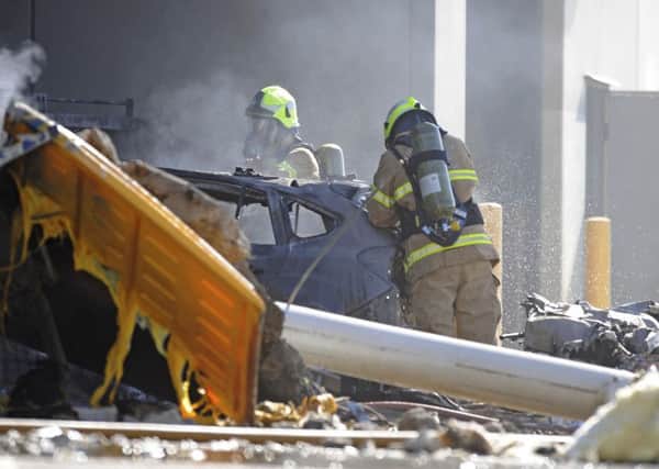 Emergency personnel work at a light plane crashed in Melbourne, Australia, Tuesday, Feb. 21, 2017. The plane crashed into a shopping mall, officials said. (Joe Castro/AAP Image via AP)