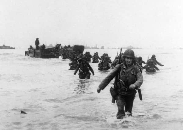 Allied soldiers come ashore on D Day