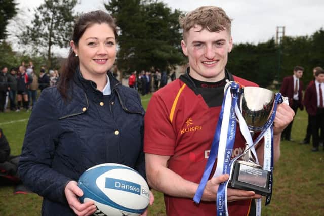 Foyle captain Thomas Cole celebrates winning the Trophy along with Lisa Hughes from Dunganon