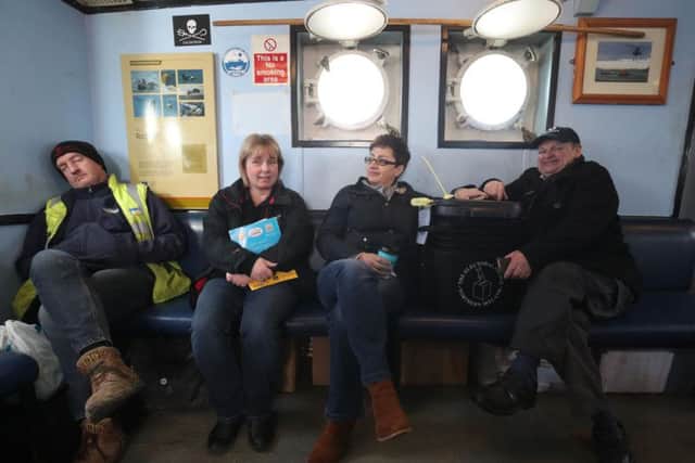 Senior presiding officer and polling station manager Teresa McCurdy (second right) on her way to Rathlin Island, off the north east coast of Northern Ireland, with the ballot box in which the island's population of just over 100 people will cast their votes during Thursday Assembly election