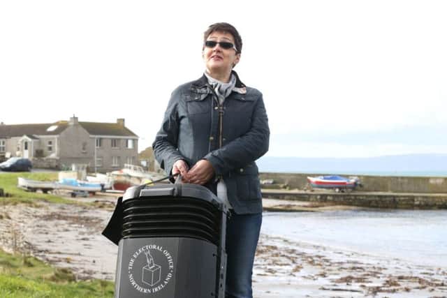 Senior presiding officer and polling station manager Teresa McCurdy on Rathlin Island, off the north east coast of Northern Ireland, with the ballot box in which the island's population of just over 100 people will cast their votes during Thursday Assembly election.