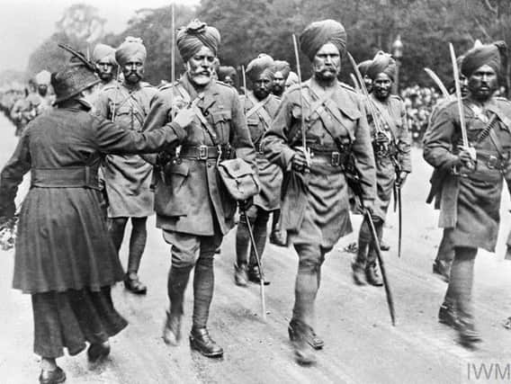IWM Undated Imperial War Museums handout photo of a woman offering flowers to marching Indian troops (some of them Muslim) during the First World War.