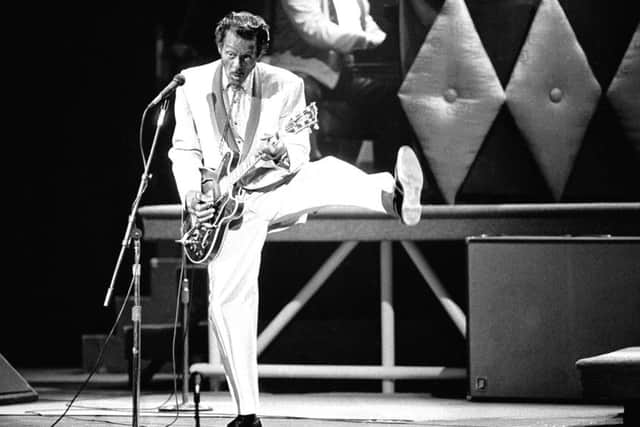 In this April 4, 1980 file photo, guitarist and singer Chuck Berry performs his "duck walk" as he plays his guitar on stage