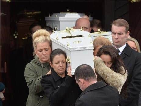 Louise James carrying the coffin of one of her children