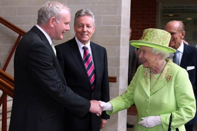 The Queen shaking hands with Martin McGuinness watched by First Minister Peter Robinson (centre) at the Lyric Theatre in Belfast.  Photo: Paul Faith/PA Wire