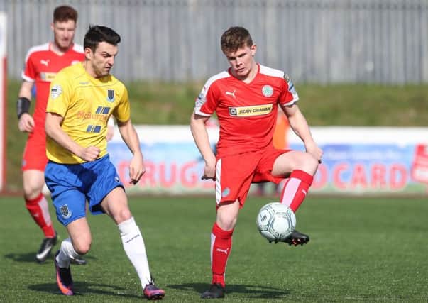Cliftonville's Levi Ives in action with Ballymena's Conor McCloskey