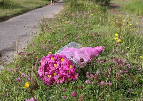 Flowers left at the spot in Colin Glen where Gary Lewis knocked down and killed Valerie Armstrong