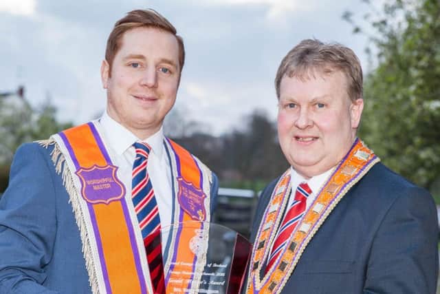 Deputy grand master of the Grand Orange Lodge of Ireland, Harold Henning, presents the Grand Master's Award to Barry Williamson at last night's annual community awards