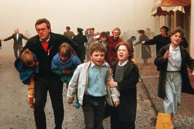 Panicking people flee the scene of the IRA 1987 Poppy Day bombing which killed 12 people and injured many more