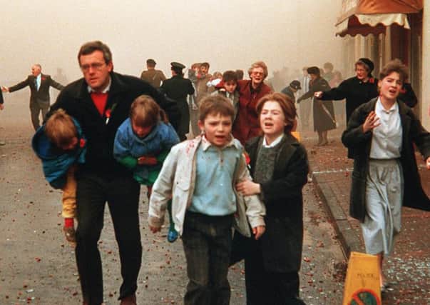 Panicking people flee the scene of the IRA 1987 Poppy Day bombing which killed 12 people and injured many more