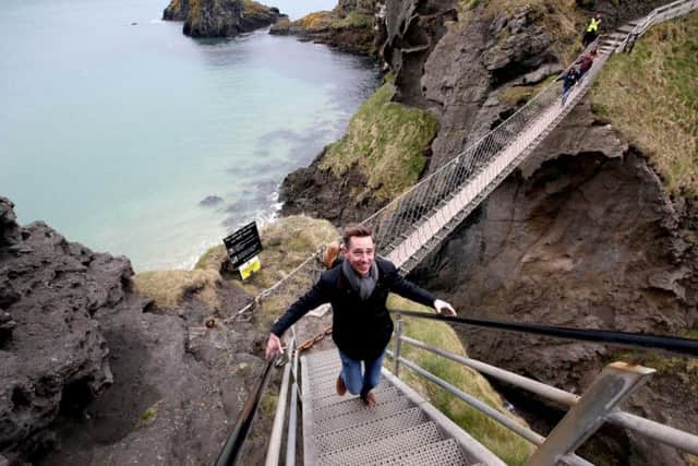 All smiles... RTE presenter Ryan Tubridy tackles Carrick-a-Rede rope bridge