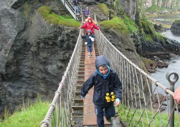 Visitors make the dramatic crossing at the iconic bridge beside the Giant's Causeway